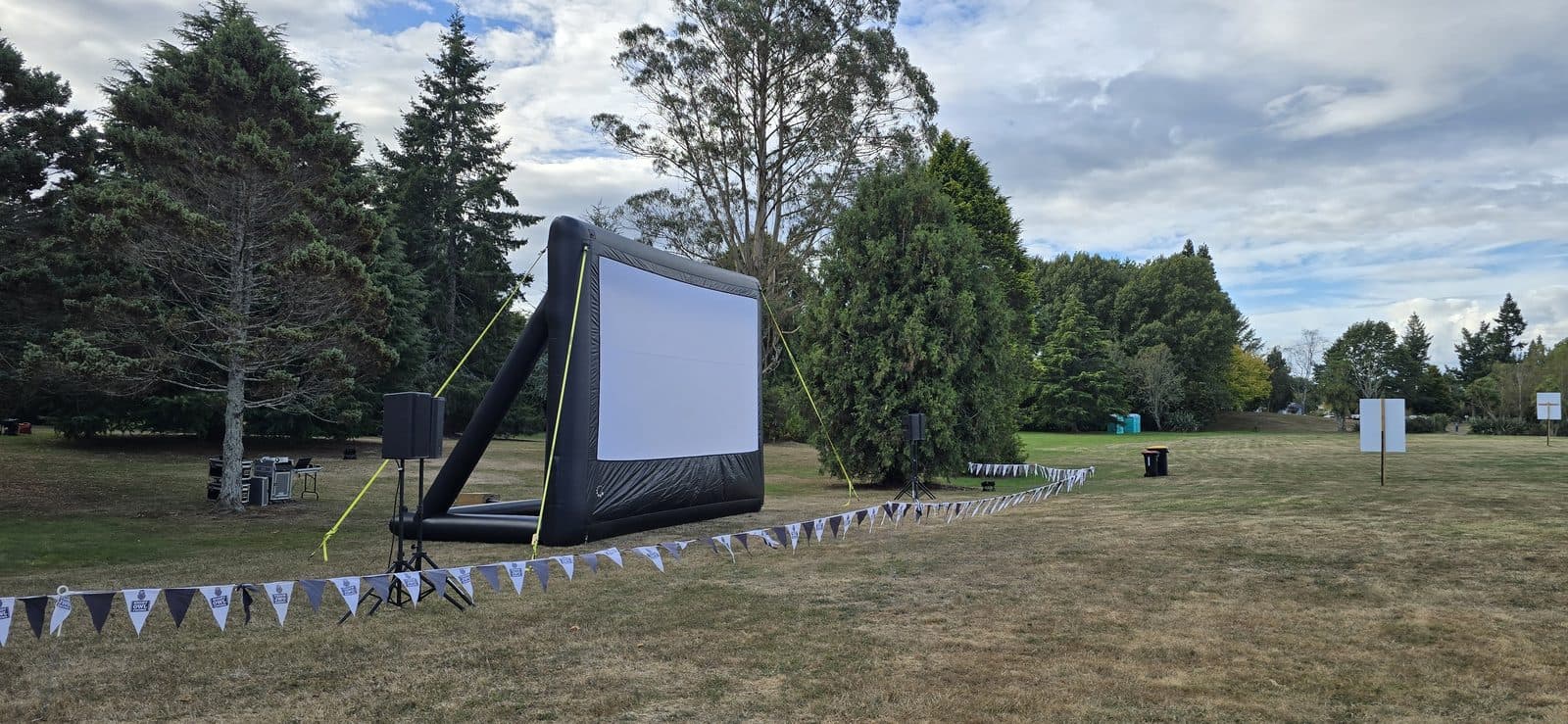 Outdoor cinema screen set up on a field for a school community fundraiser night